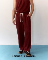 (Leisure Projects) LIGHT KNIT PANTS กางเกงเอวยางยืด ผ้าทอ ขาตรง ตกเเต่งด้วย logo โลหะ