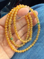 翡翠冰黃翡珠串  如凝結的蜜糖沁入寒冰，圓珠似琥珀色的星星墜入清泉。淺金與鵝黃在剔透的冰種底子裡暈染，似薄霧晨曦穿透冰層，流轉間泛起冰糖融化般的瑩潤光澤。珠體通透如凍，卻裹著蜜蠟般的暖意，冷與暖在指尖