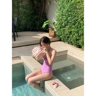 Pink 1-piece swimsuit with vertical stripes shows off the gentle figure of the muse