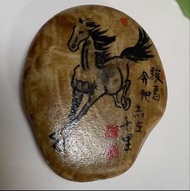 石頭上的文字為「駿馬馳千里」