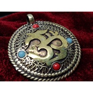 Round 3D pendant with either Om or Kalachakra symbol from Nepal