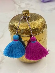 Saudi Arabia Scented candle in a gold, hammered-finish container with two colorful tassels. 中東香薰蠟連金屬