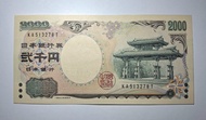 日本 2000 日元紙幣，日本的「二千円紙幣」，由日本銀行於2000年發行，至今仍是有效法定貨幣，但因流通量極低而被視為罕見收藏品。正面圖案是沖繩首里城的守禮門，背面則是《源氏物語》的繪卷與紫式部肖像