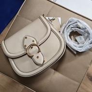 清衣櫃💢全新 Coach Beat Saddle 手袋，採用杏色皮革製成，配有標誌性的 C 字扣環。手袋內襯為棕色，附有可拆卸肩帶。附有吊牌和防塵袋，並有收據證明。款式簡約時尚，適合日常搭配。