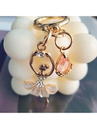 一個合金材質的跳舞女孩鑰匙扣，配有粉紅色的鑽石，適用於手提包的日常使用或裝飾。是情侶們不錯的小禮物。