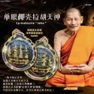 Thailand's most popular monk, Luang Phor Mahasila, presents a single-eyed coconut shell Rahu amulet.