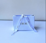 極新中型Dior（迪奧）專櫃白色紋理紙質禮品袋，正面印有品牌標誌性的金色 DIOR 字樣，並搭配印有品牌標誌的白色緞帶，通常用於包裝香水、口紅或護膚品等彩妝奢華禮品。7.75吋濶5.5吋高3吋高。