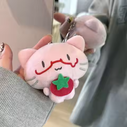 The Cute Pink Kitten Is Wearing Playful Red-rimmed Glasses and Holding Round Little Tomato in Her Ar