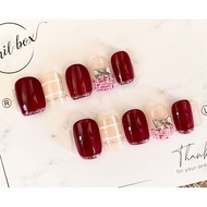 Red nails designed with cute bow charms