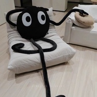 Black briquette pillow with long sleeves and legs, cute briquette monster doll.