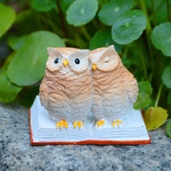 Double owl reading resin figurine, presenting the image of two owls perched atop books, exudes an au