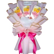 Buket snack Pocky kado ulang tahun dan wisuda dengan kemasan bunga berwarna pink dan pita satin.