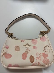 精緻優雅的 Coach Teri 日本限定櫻花印花肩背包，點綴著柔美淡雅的粉色與棕色花卉圖案。