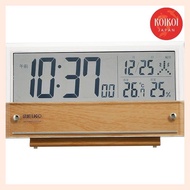 Seiko Clock SQ782B is a tabletop clock and alarm clock with digital calendar, temperature and humidity display, and transparent LCD. It also receives radio waves and has a thin brown wooden design. The size of the body is 10.7×19×4.1cm.