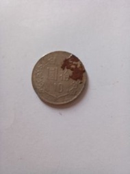 這是一枚面值為 拾圓 的中華民國流通硬幣。

硬幣背面印有數字 10 以及梅花圖案。