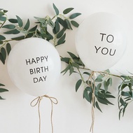 2 balloons printed with the words happy birthday+ to you