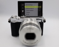 Nikon 1 J5 20.8MP  บันทึกภาพสุดน่าทึ่งด้วยความเร็วในการถ่ายภาพต่อเนื่องที่เร็วอย่างเหลือเชื่อถึง 20 ภาพต่อวินาทีเมื่อใช้การติดตามระยะโฟกัสอัตโนมัติและวิดีโอสูงสุดถึง 4K ด้วยจอภาพ LCD ปรับเอียงขึ้นได้ 180° รวมถึงหน้าจอสัมผัส ระบบควบคุมแบบปรับเองทั้งหมด เอ็