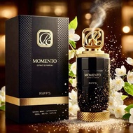 แบรนด์ MOMENTO น้ำหอม MOMENTO RIFFS ขวดสีดำพร้อมฝาทอง กลิ่นหอมธรรมชาติ ขนาด 50 มล. วางบนโต๊ะพร้อมดอก