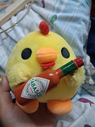 A cute chicken holding Tabasco