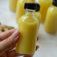 Glass bottle containing Ginger Shot 30ml-50ml in a plastic cap containing ginger shot, essential oil