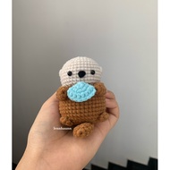 Wool Otter holding a seashell keychain