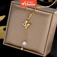 A stainless steel pendant necklace featuring an M-initial charm with a tassel, styled for fashion an