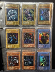全套早期超稀有或更高稀有度的遊戲王卡牌：黑魔導、青眼白龍和真紅眼黑龍。