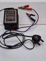 這是一組復古的 4V 充電器及其電源線與鱷魚夾配件。復古 4V 充電器：黑色外盒標示輸入為 220V 交流電，專為 4V 充電電池設計。